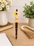 Sunflower pen, dark brown with gold accents, white-yellow flower and amber bead top
