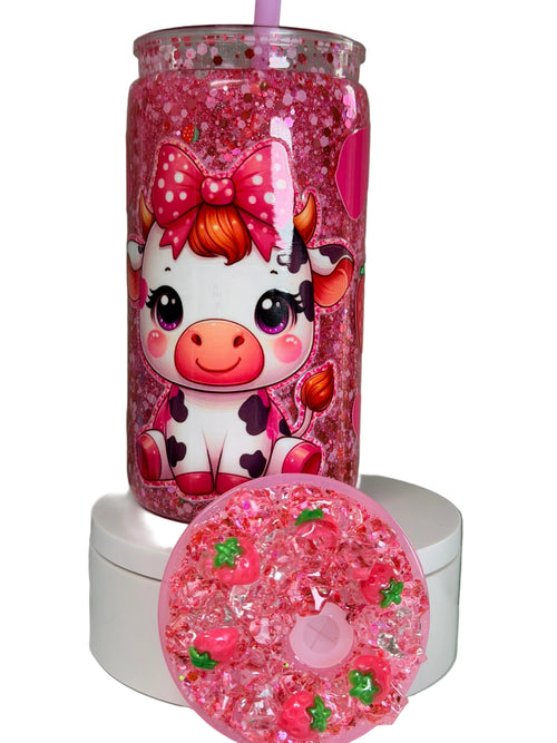 Pink glitter acrylic cup with cow-and-strawberry graphic, pink straw, spare lid