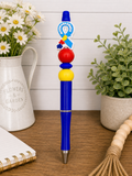 Blue autism awareness pen with puzzle-piece charm, red and yellow bead accents