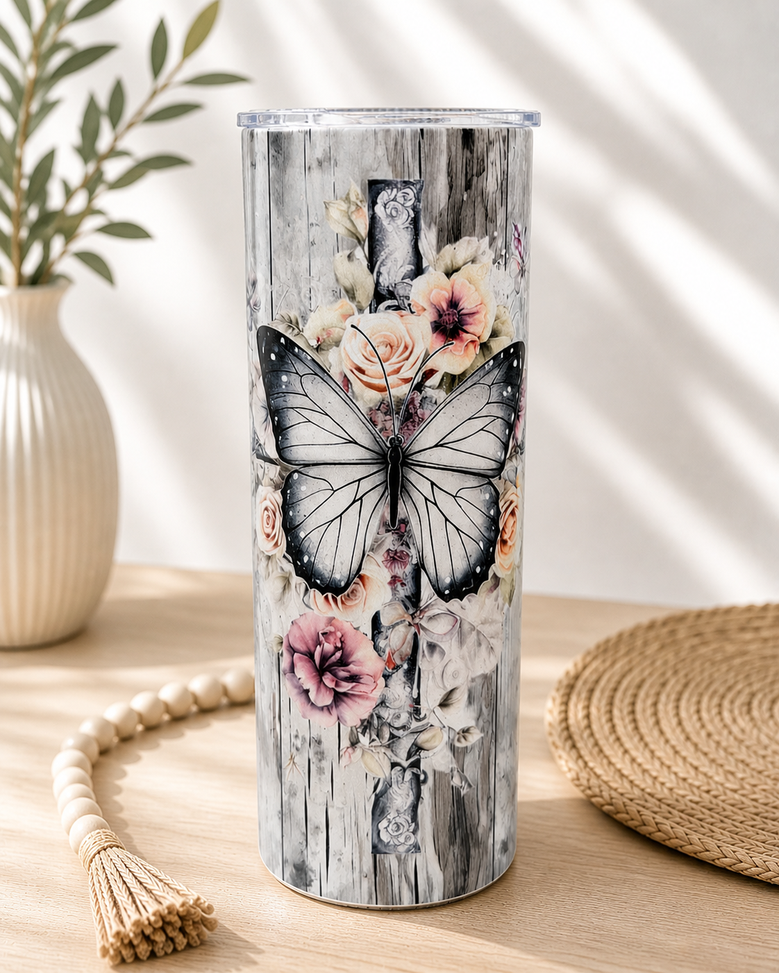 Stainless steel cup with floral butterfly graphic and dark wooden texture background
