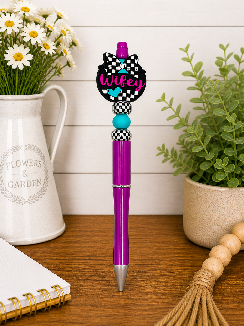 Purple ballpoint pen with checkered bow topper and teal bead accents