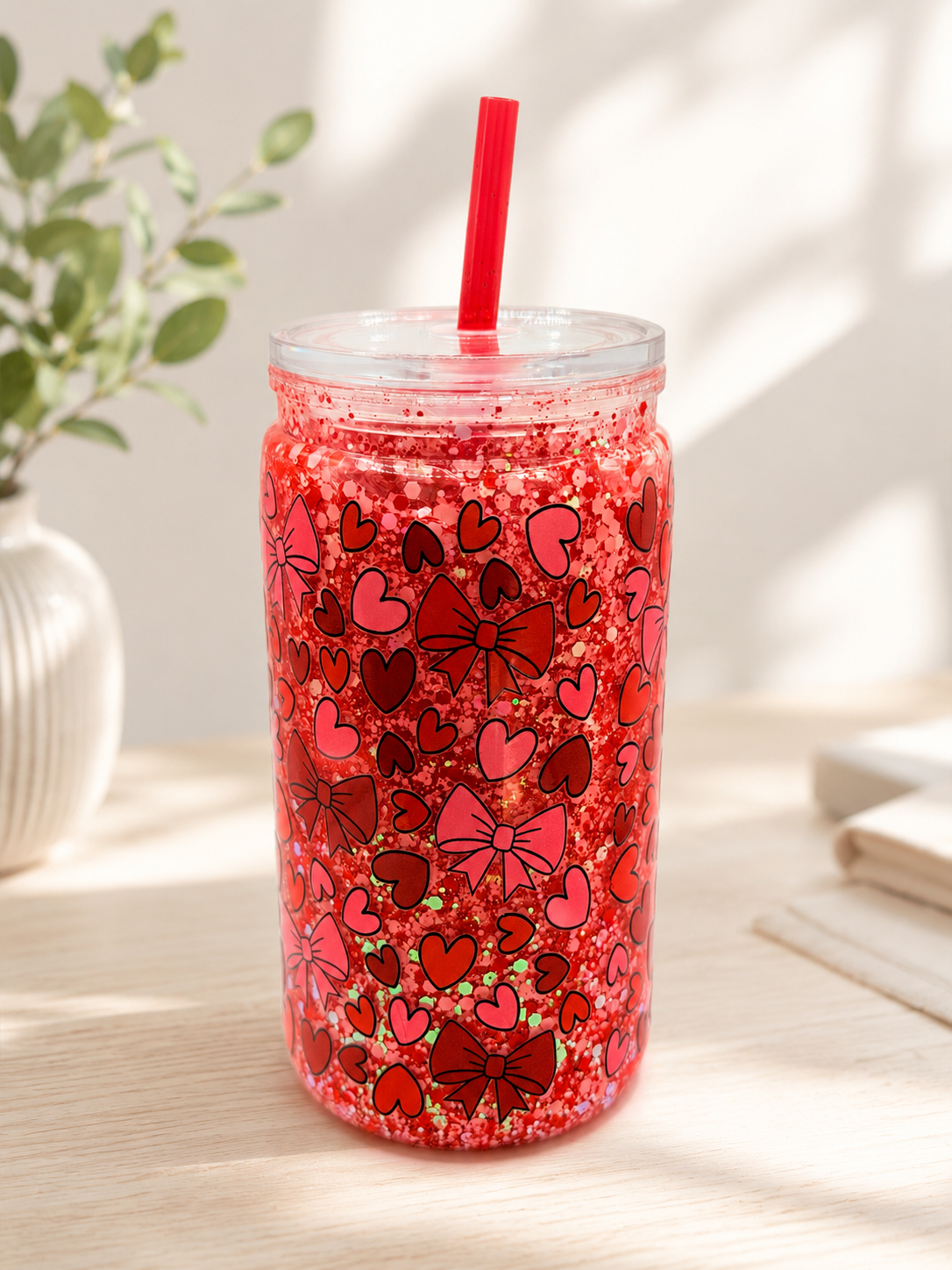 Red glitter 16 oz tumbler with heart pattern, clear lid, and red straw