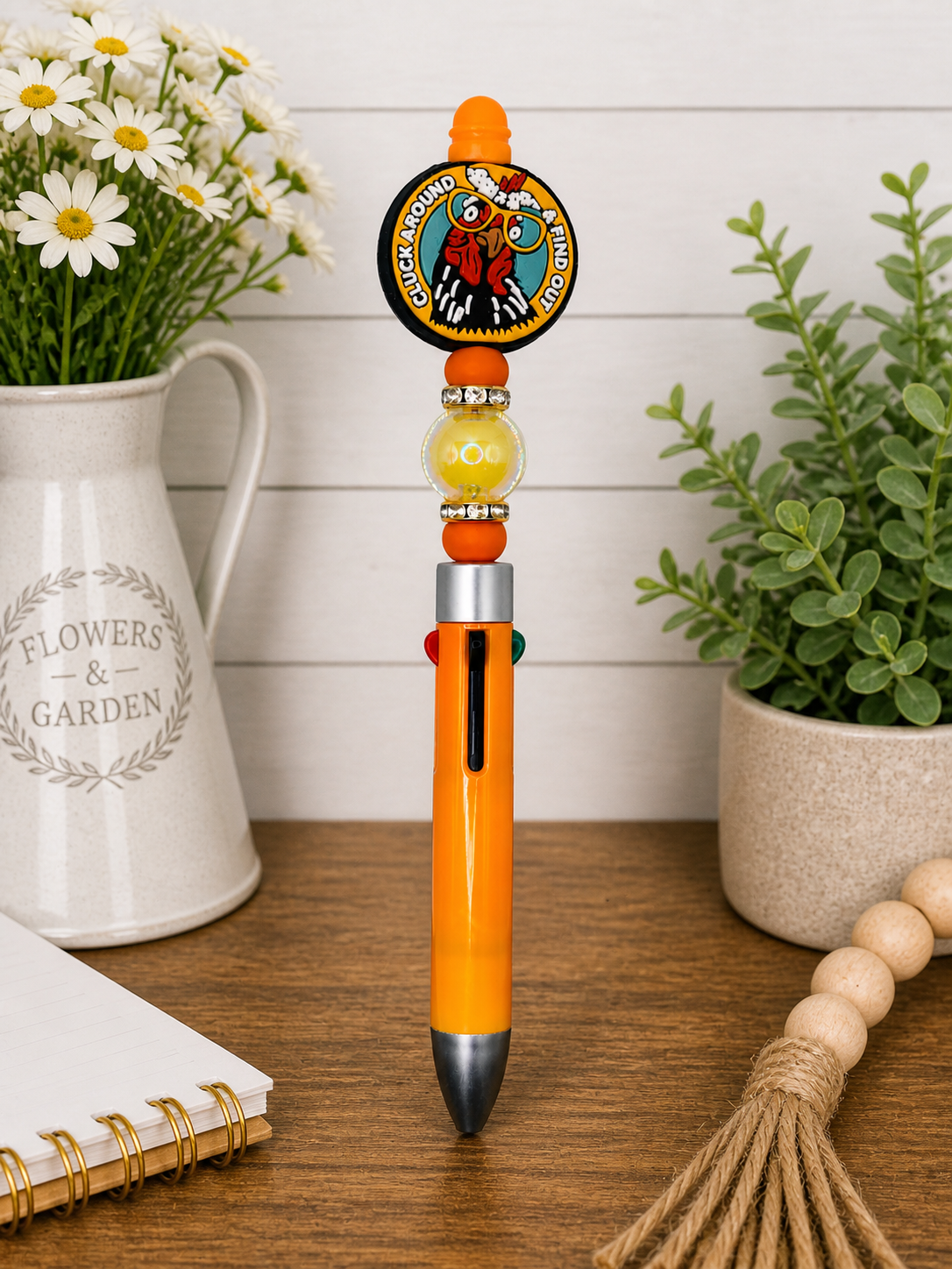 Orange novelty pen with round chick badge charm, bead accents, and black tip