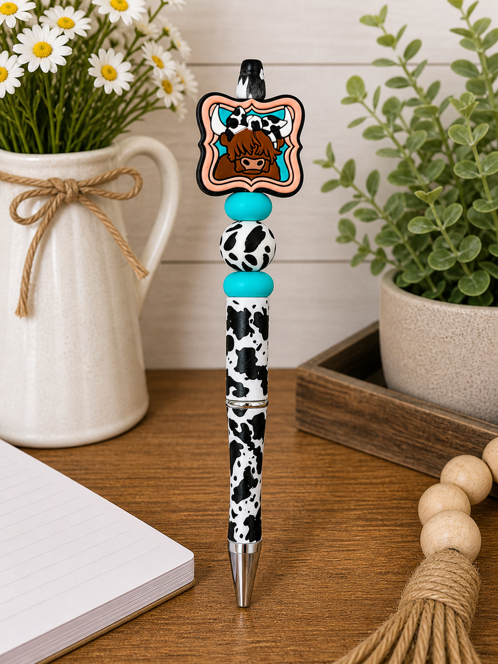 Cow-themed novelty pen with black and white spotted barrel and bow charm
