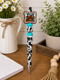 Cow-themed novelty pen with black and white spotted barrel and bow charm
