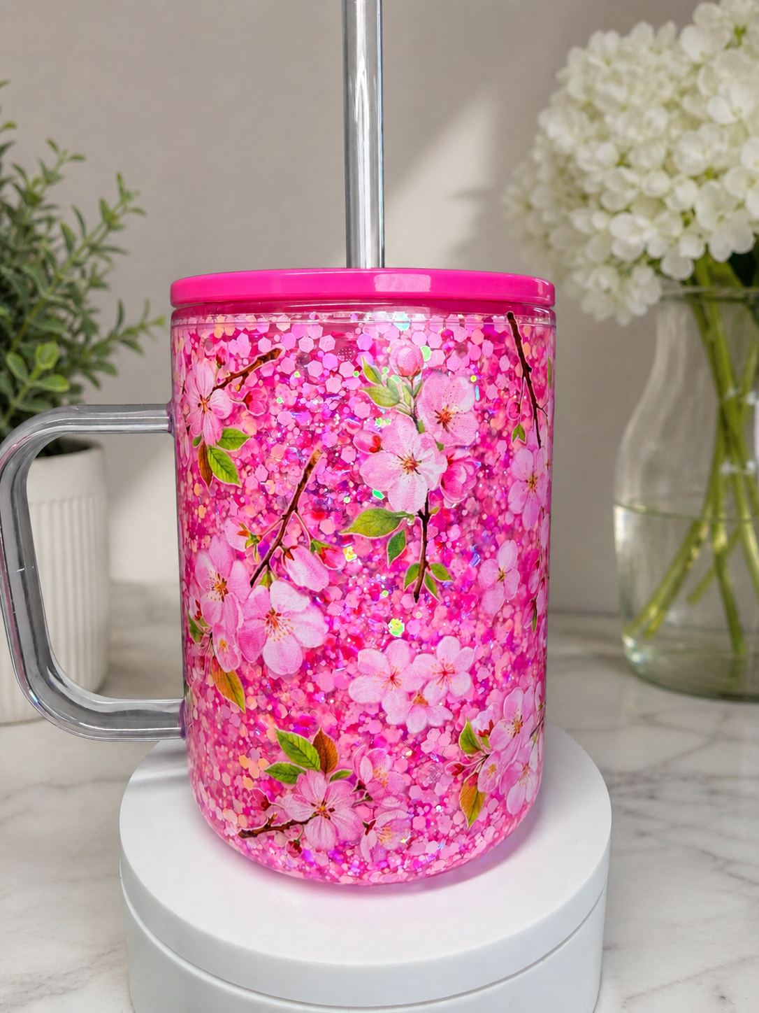 Pink 17 oz coffee mug with pink floral glitter, side handle and magenta lid