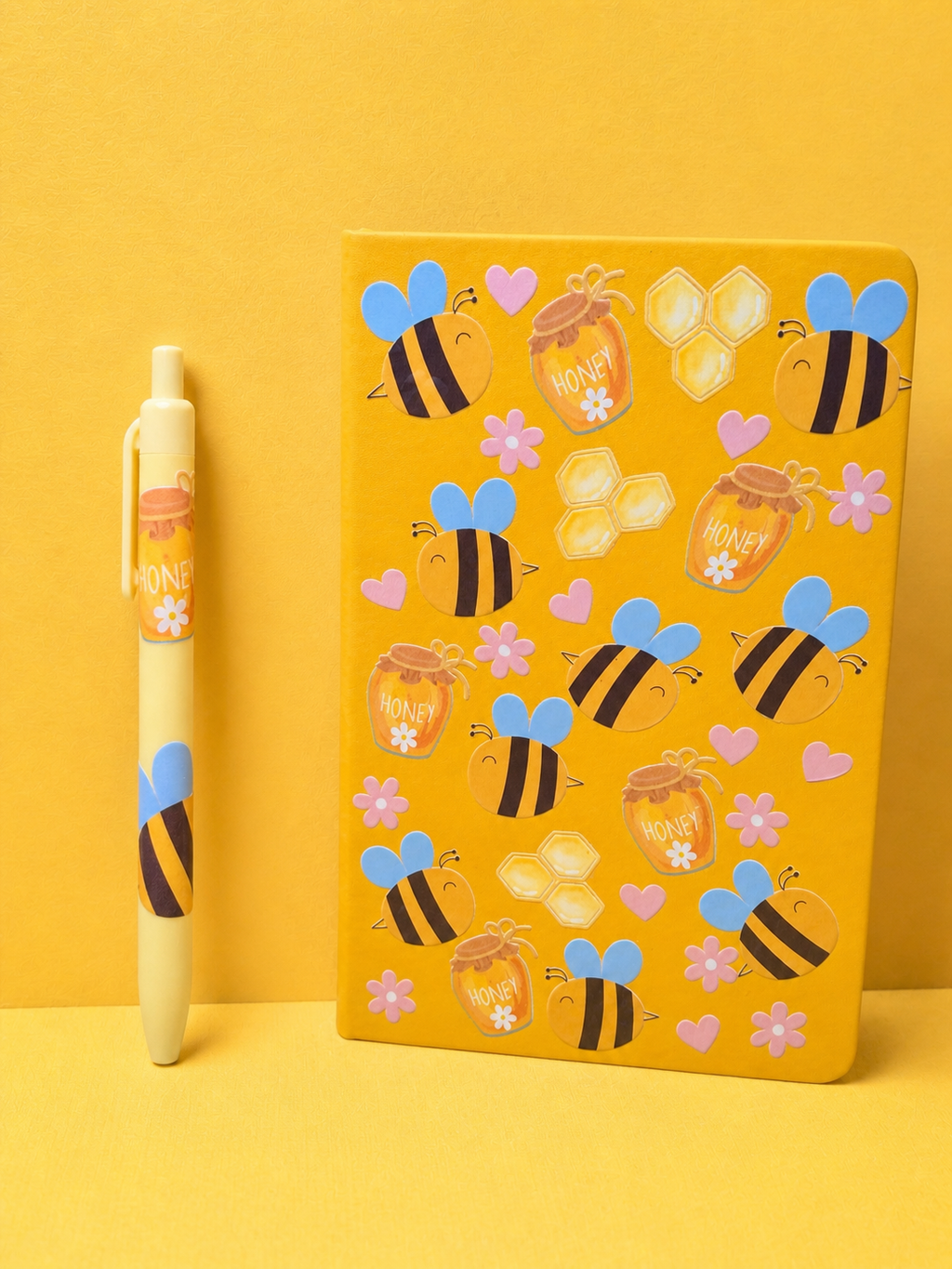Yellow A5 notebook with bee decals and hearts, plus matching pen with honey theme