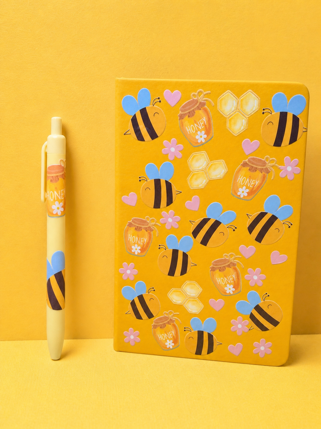 Yellow A5 notebook with bee decals and hearts, plus matching pen with honey theme