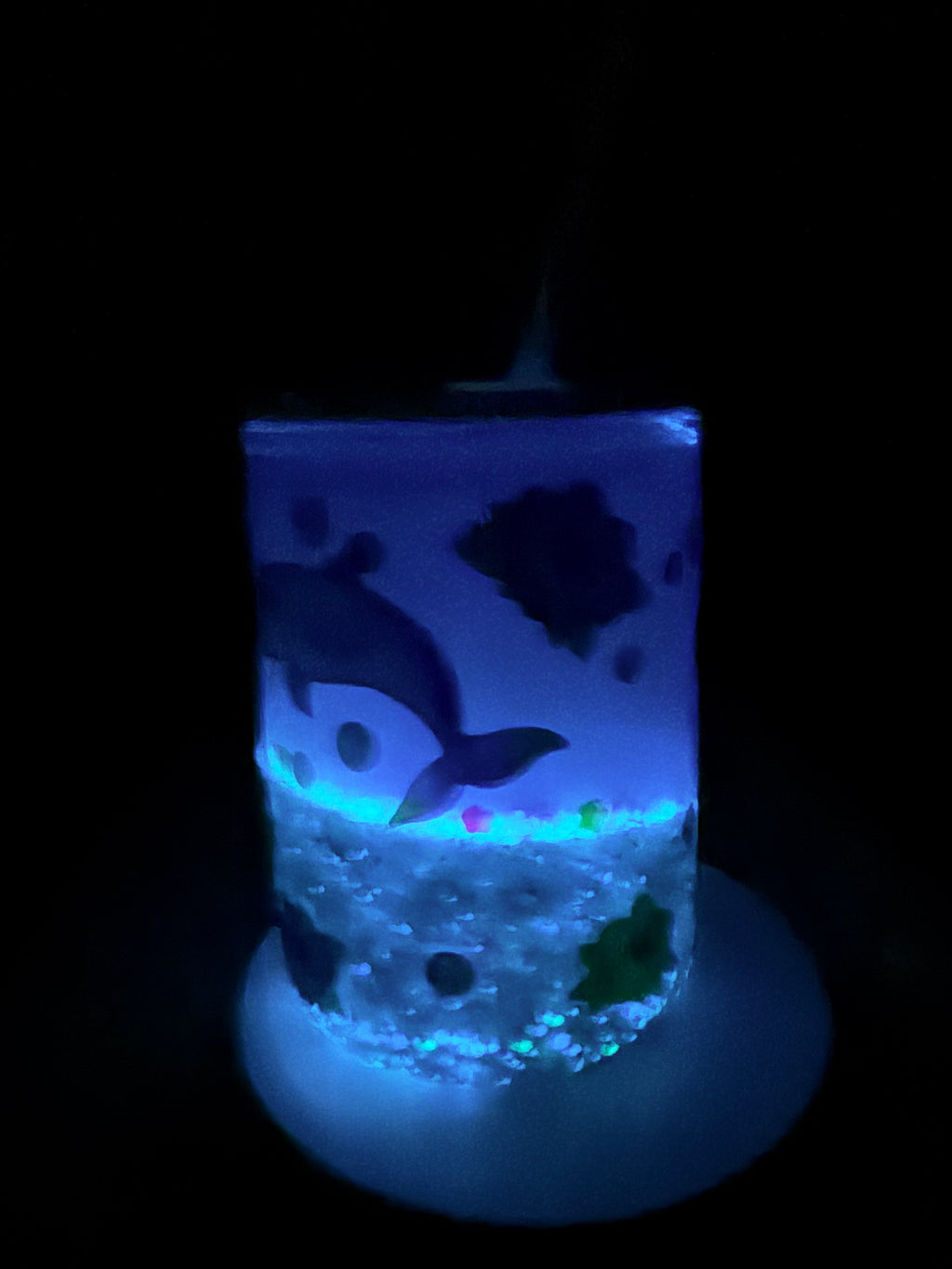 Acrylic coffee mug glowing blue with dolphin and turtle scenes, clear handle.