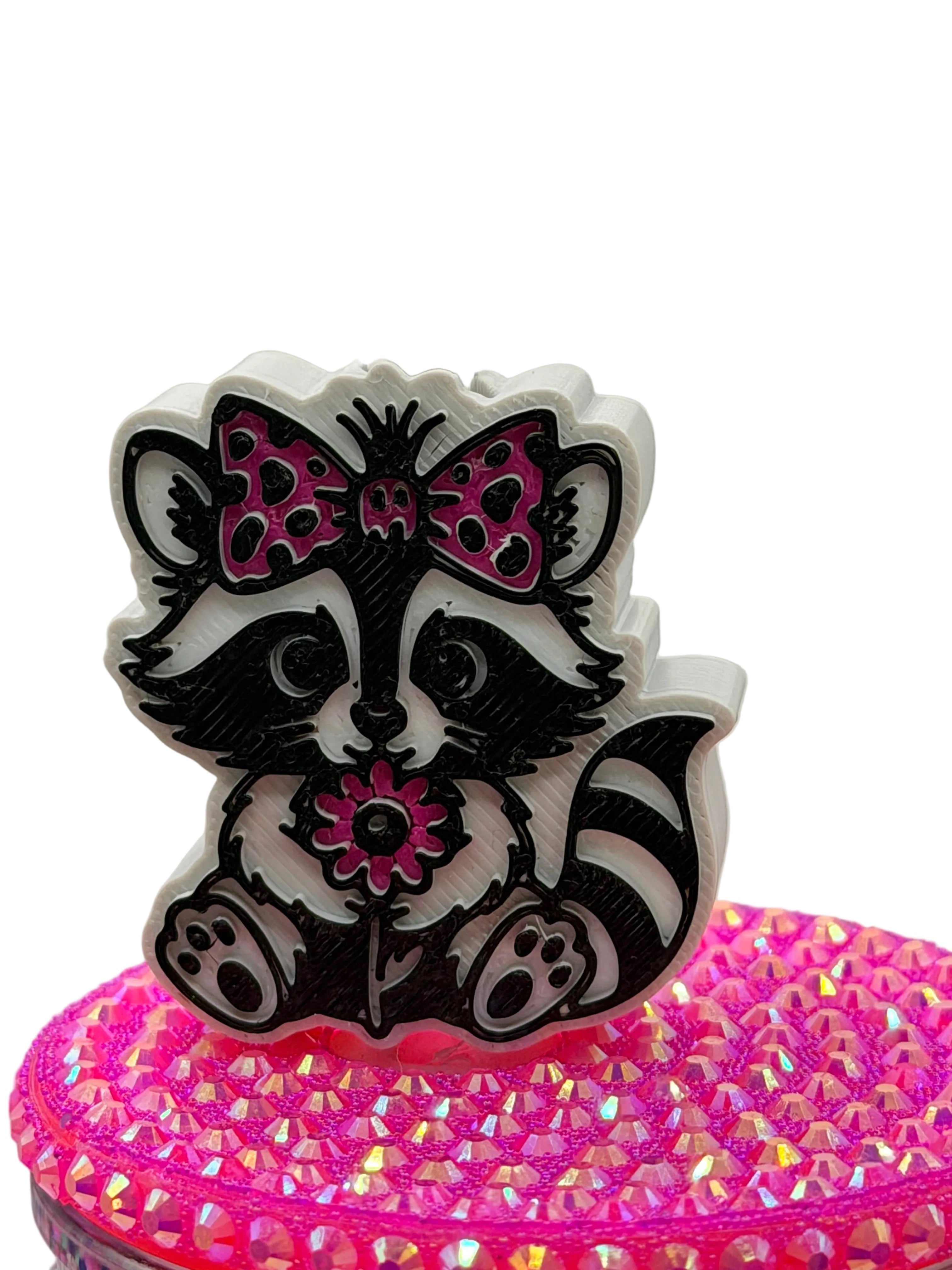 Glitter cup lid topper with raccoon skunk face graphic and pink bows
