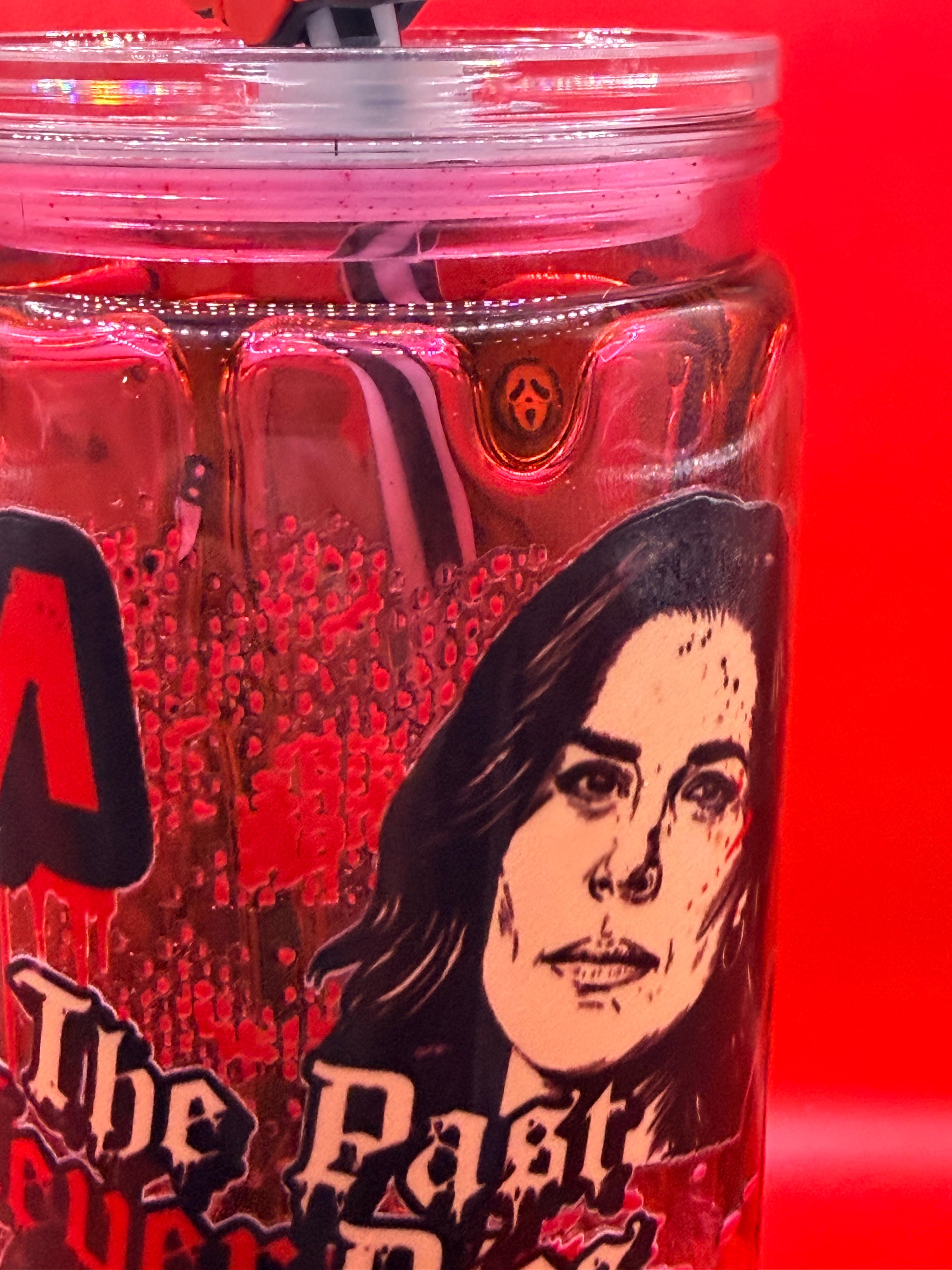 Close-up 16 oz SCREAM drip cup with red lid and woman face graphic