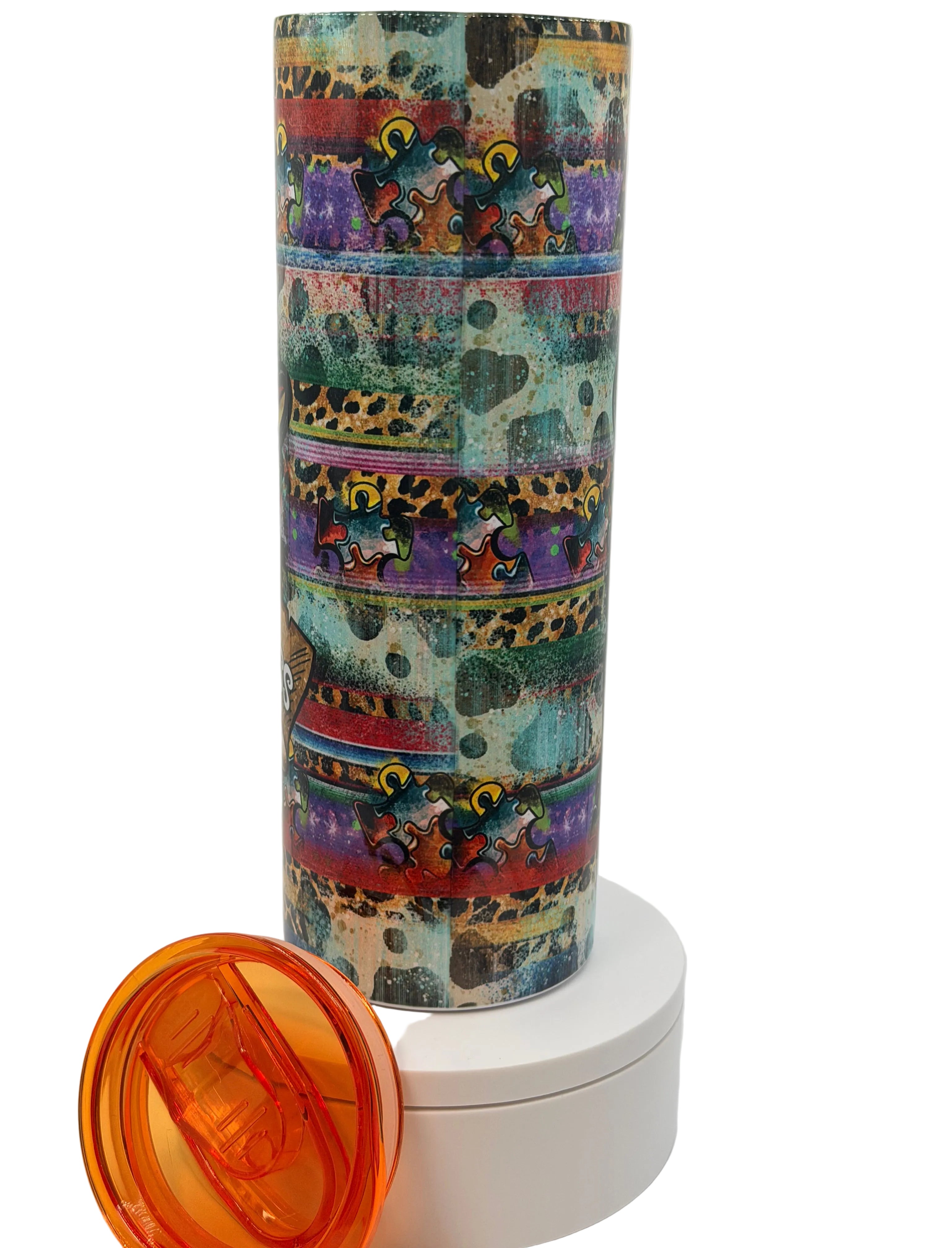 Stainless steel autism awareness cup with vertical colorful puzzle-pattern graphic and orange lid