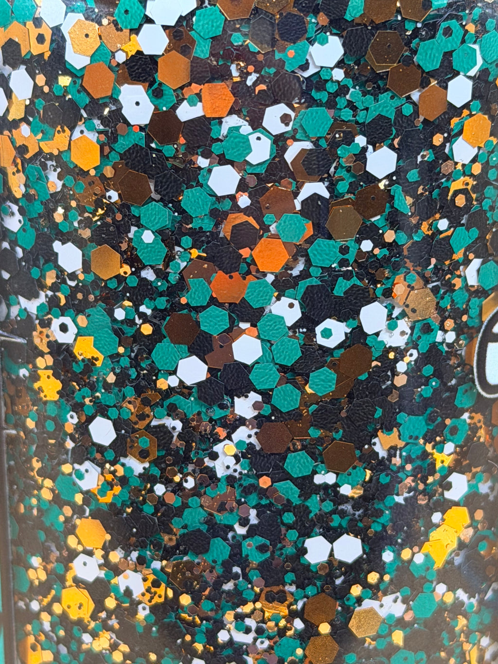 Close-up of multicolor hex glitter flakes in a snow globe cup
