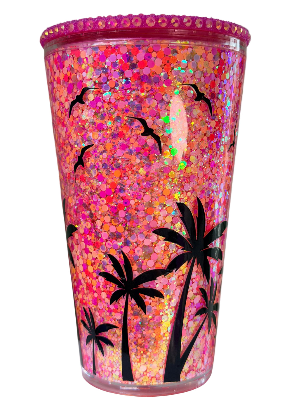 Glitter acrylic snow globe tumbler with pink-orange sparkle and black palm tree graphic