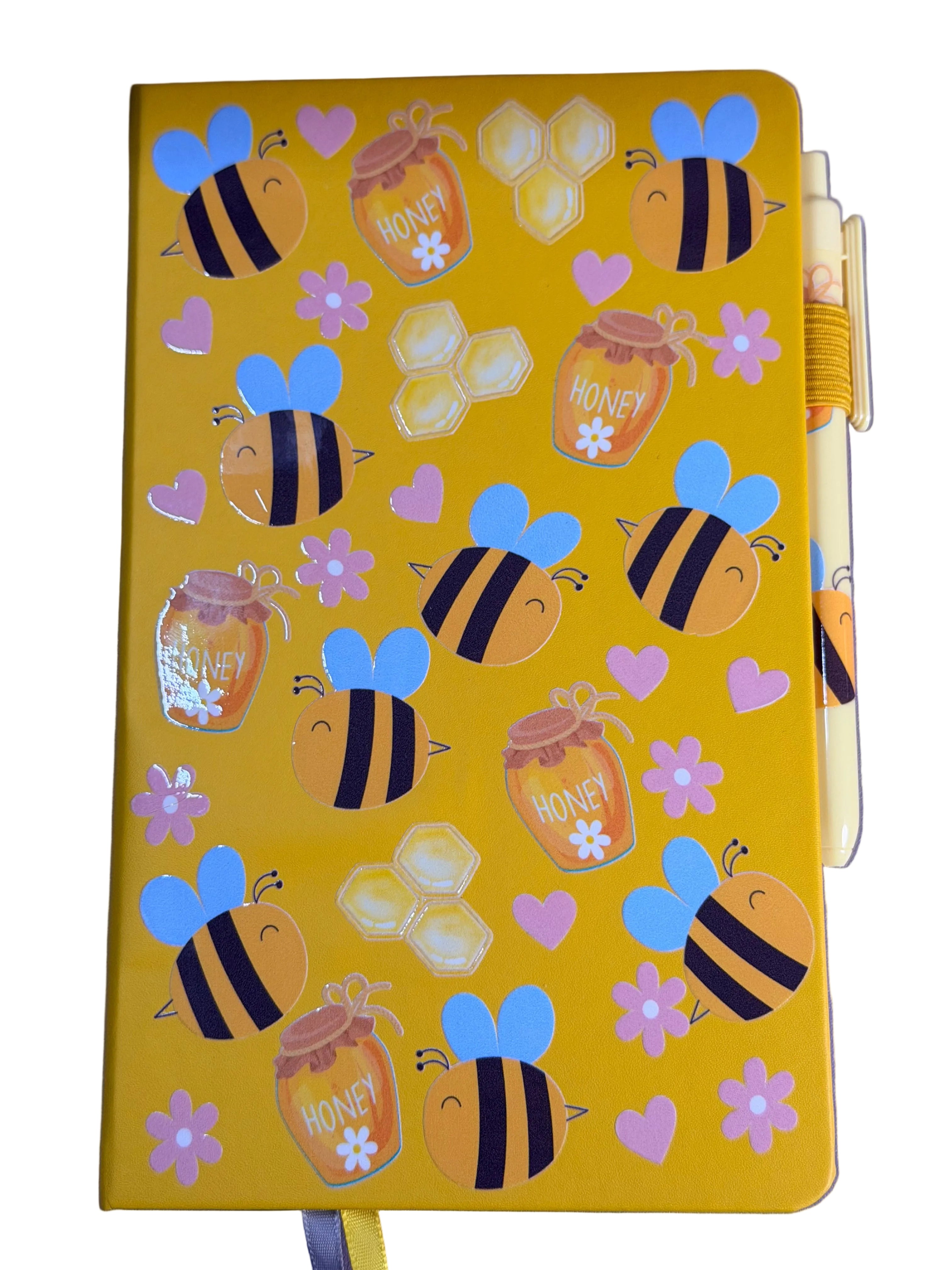 Yellow A5 notebook with bee and honeycomb decals; matching pen tucked at right