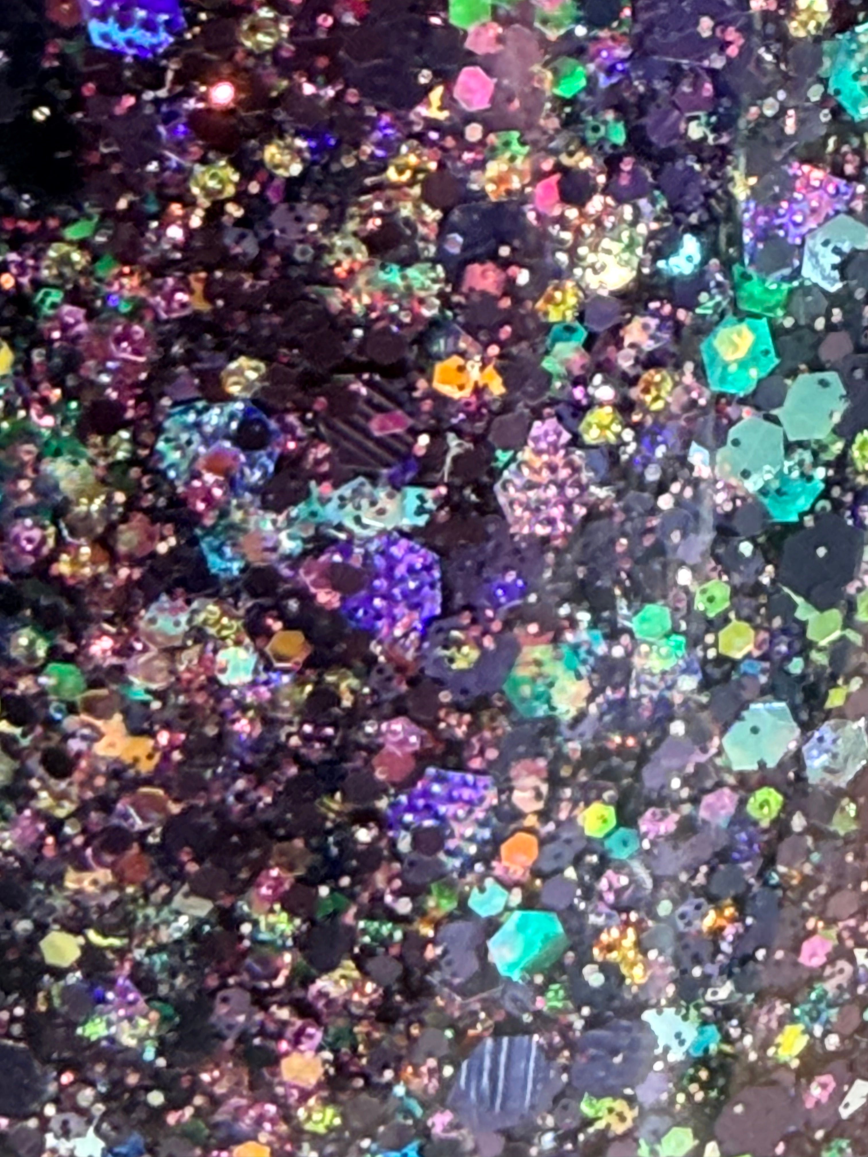 Colorful acrylic glitter mix close-up in dark base for tumblers